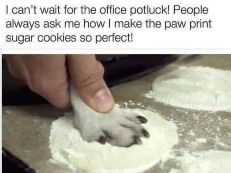 Person's hand pressing paw print sugar cookie dough with text about making paw print sugar cookies.