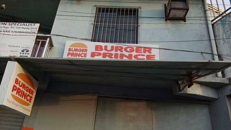 Sign for Burger Prince, a parody of Burger King, on a building.