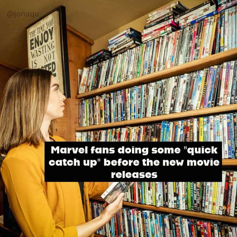 Marvel fans browsing DVDs in a store, preparing for new movie release.