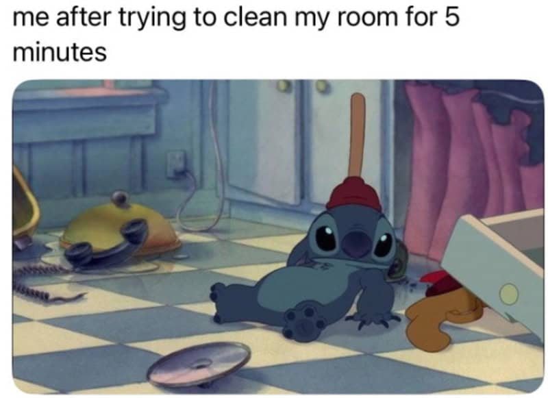 Stitch from Lilo & Stitch lying on the kitchen floor with cleaning supplies around.