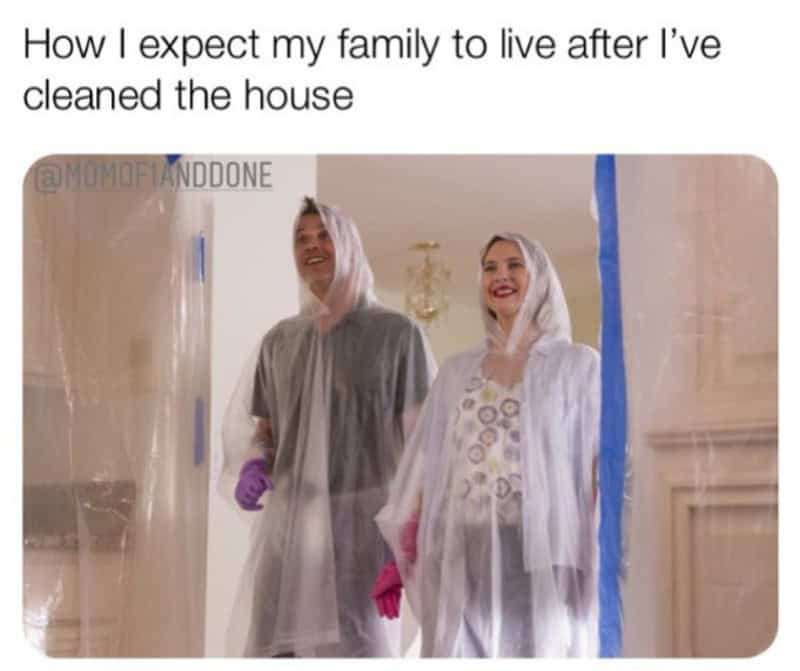 Family in plastic suits smiling after cleaning the house.