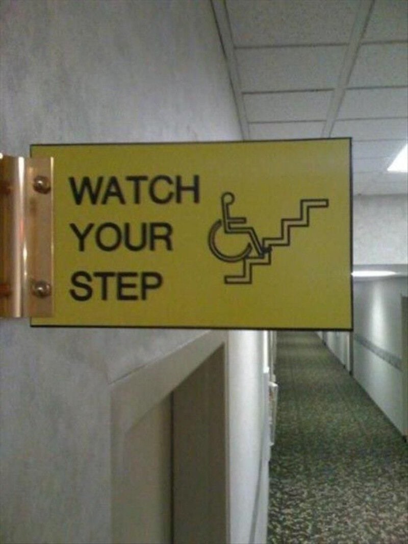 Watch your step sign with a wheelchair and stairs illustration.