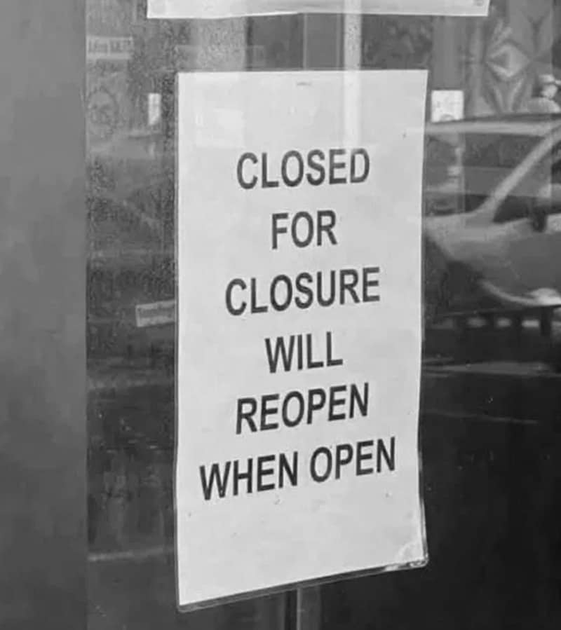 Sign reads 'CLOSED FOR CLOSURE WILL REOPEN WHEN OPEN' in black text on white paper.