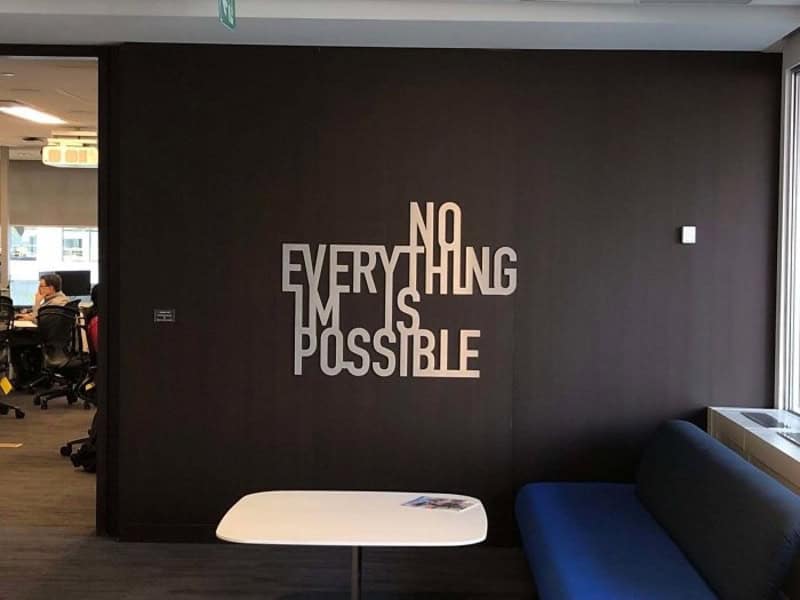 Wall sign says 'Nothing is impossible' with 'Nothing' and 'Impossible' crossed out.