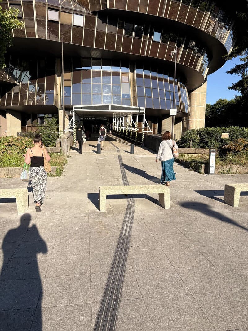 Tire tracks leading to the entrance of a modern building with curved architecture.