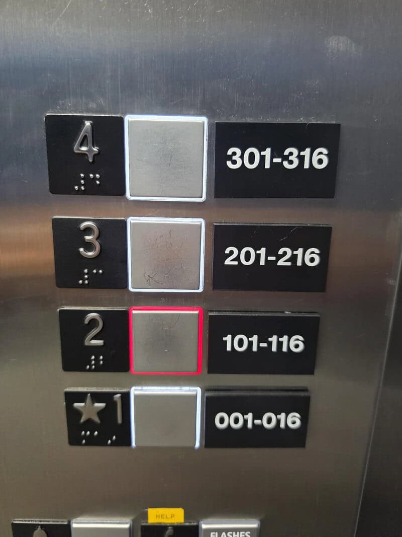 Elevator panel with missing number 5, showing floors 4, 3, 2, 1 with braille and floor ranges.