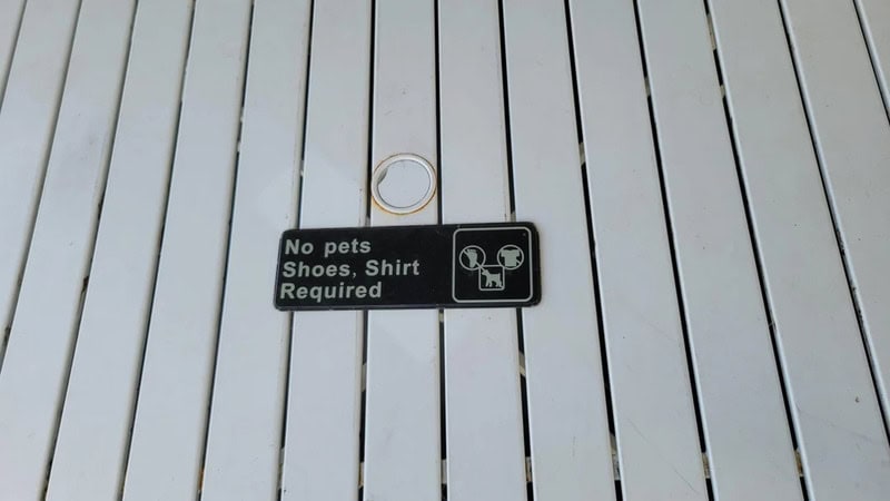 No pets, shoes, shirt required sign on wooden floor.