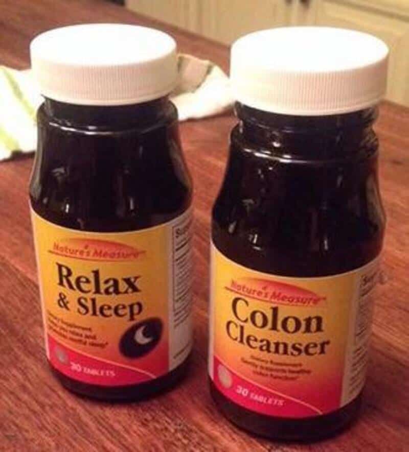 Two bottles of dietary supplements labeled 'Relax & Sleep' and 'Colon Cleanser' on a wooden surface.