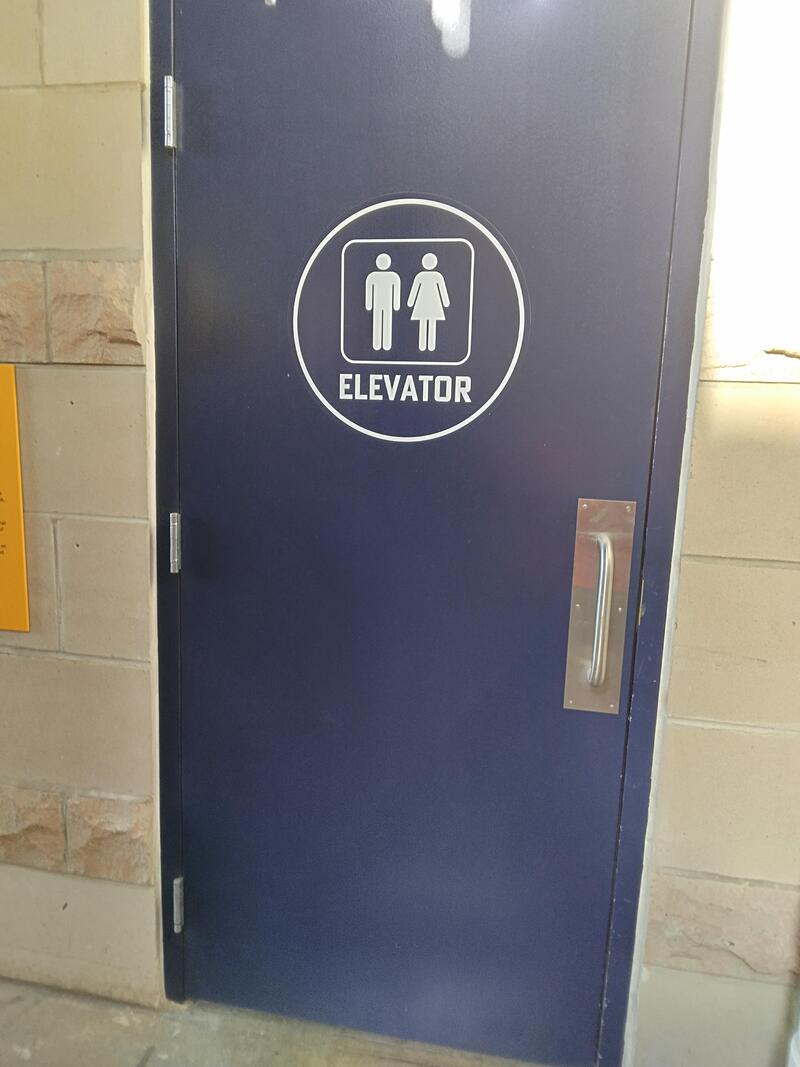 Sign for elevator with male and female icons and the word 'ELEVATOR'.