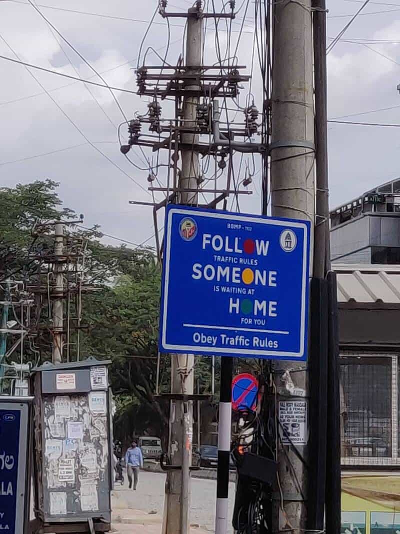 Traffic sign says 'Follow someone is waiting at home for you. Obey traffic rules.'.