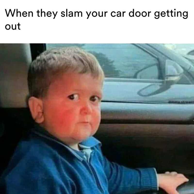 Child with a surprised expression sitting in a car, captioned 'When they slam your car door getting.