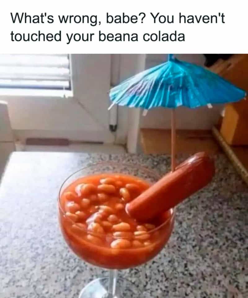Beana colada with a hot dog, umbrella, and beans in a glass.
