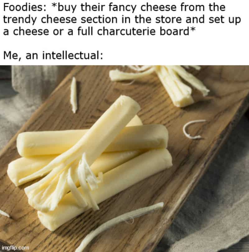 Cheese sticks on a wooden board with text about cheese and charcuterie.