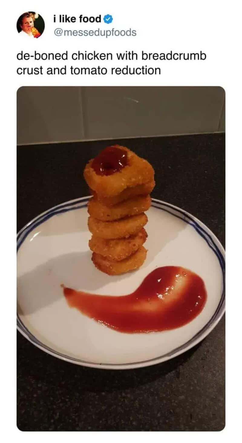 Stack of onion rings with ketchup on a white plate.