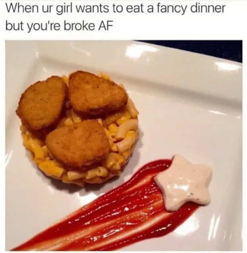 Fried chicken nuggets on a bed of macaroni and cheese with ketchup and a star-shaped dollop of sauce.