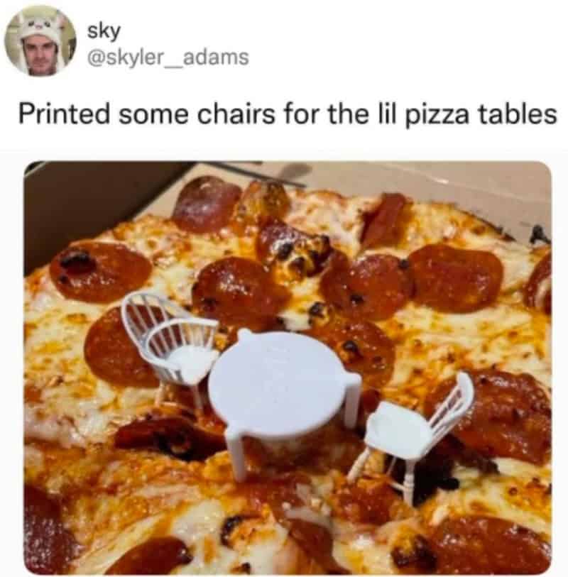 Miniature plastic chairs on a pizza resembling a pizza with pepperoni and cheese.