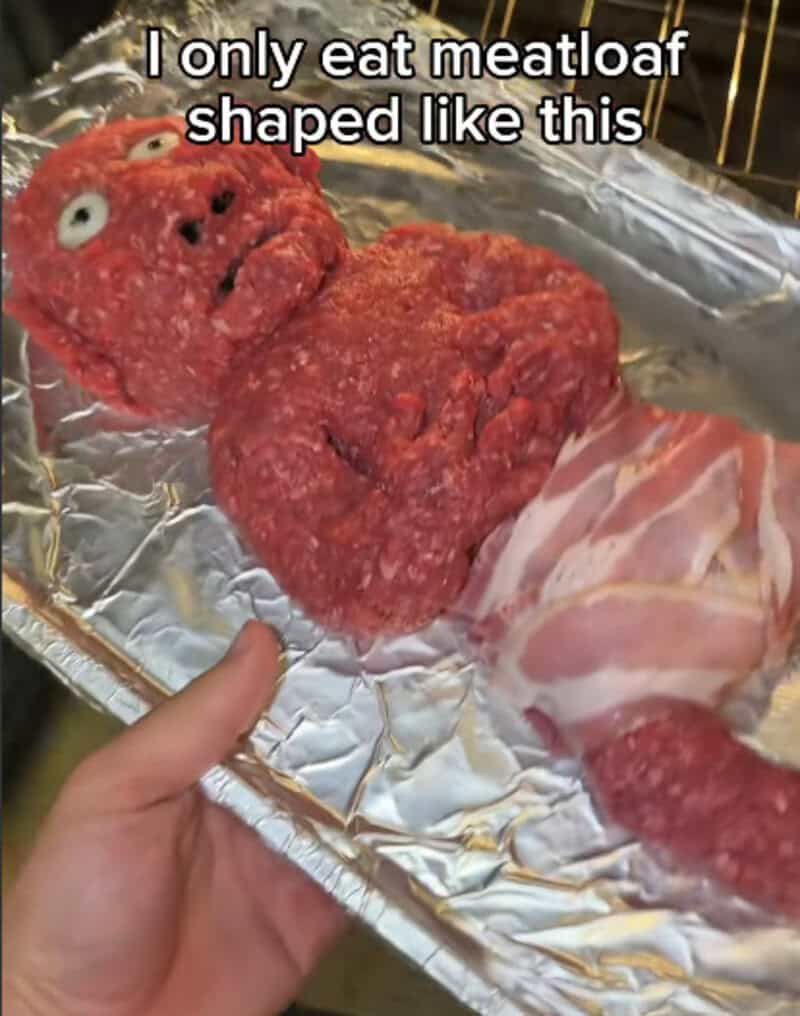 Meatloaf shaped like a face with eyes and mouth, with text about eating meatloaf.