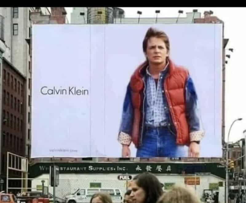 Billboard featuring a young boy in a red vest and blue shirt with 'Calvin Klein' text.