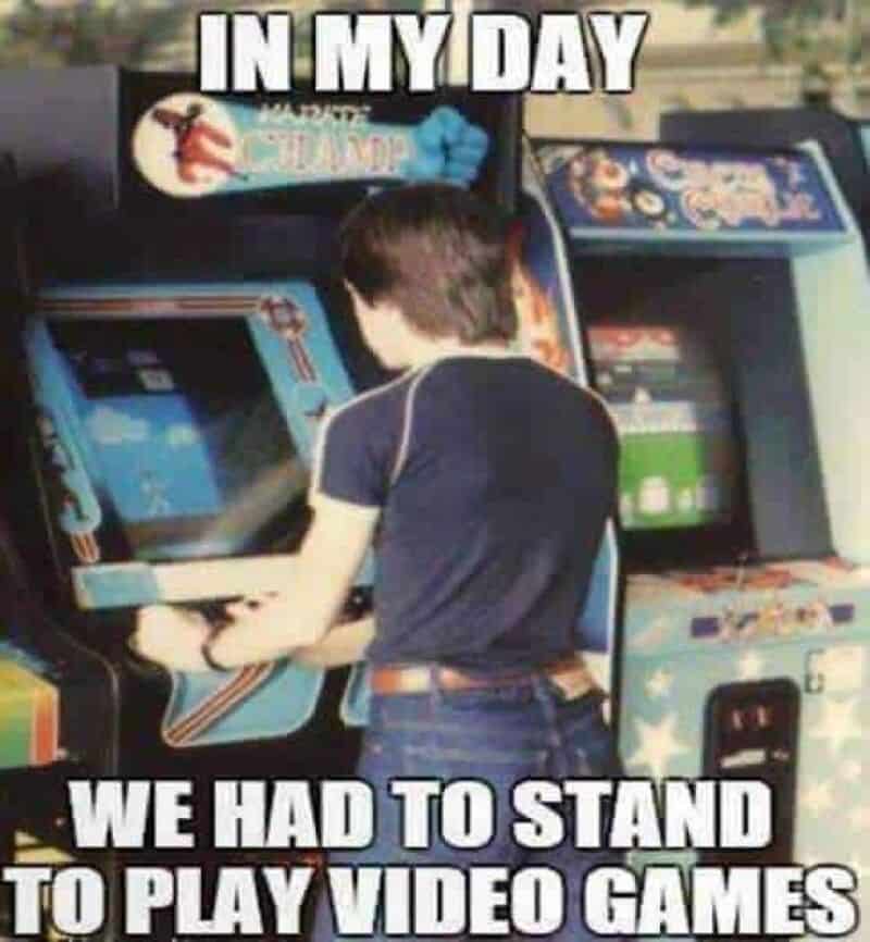 Child playing arcade game with text 'In my day we had to stand to play video games'.