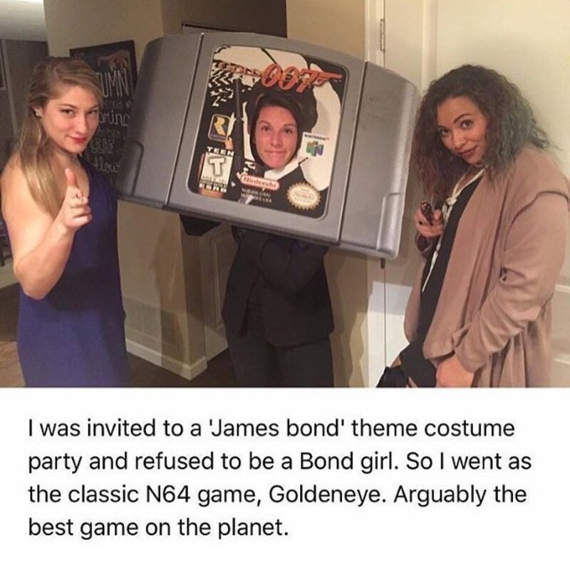 Two women with a person in a Nintendo 64 console costume at a party.