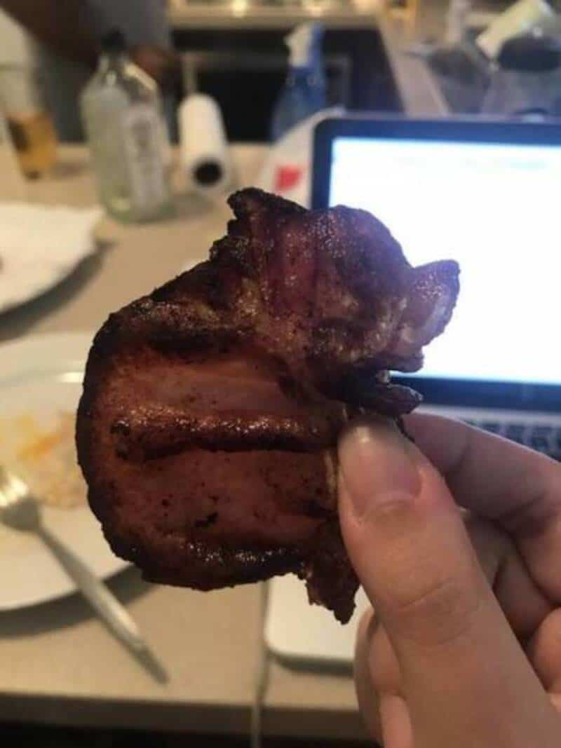 Bacon strip shaped like a cat's face with ears and whiskers.