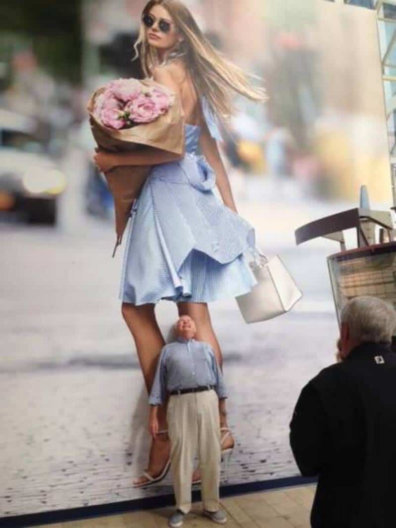 Woman with oversized head holding flowers, tiny man with big head looking up.