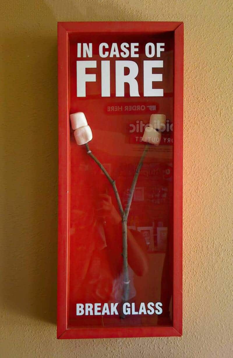 Fire alarm with two marshmallows on wires in a red case.