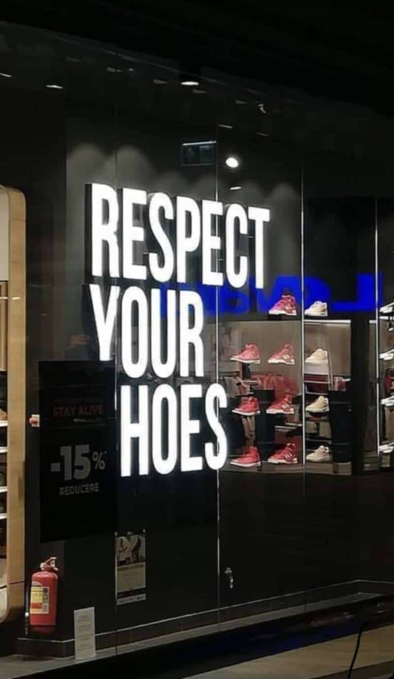 Respect your hoes sign in a store window with shoes on display.