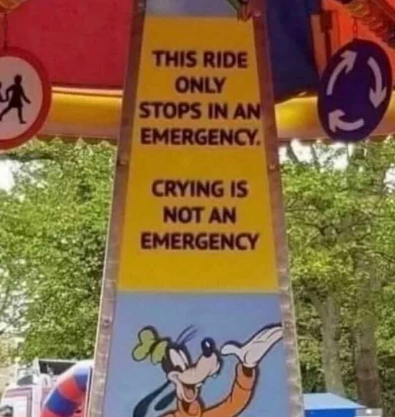 Sign on a ride says only stops in an emergency, crying is not an emergency, with a cartoon character.