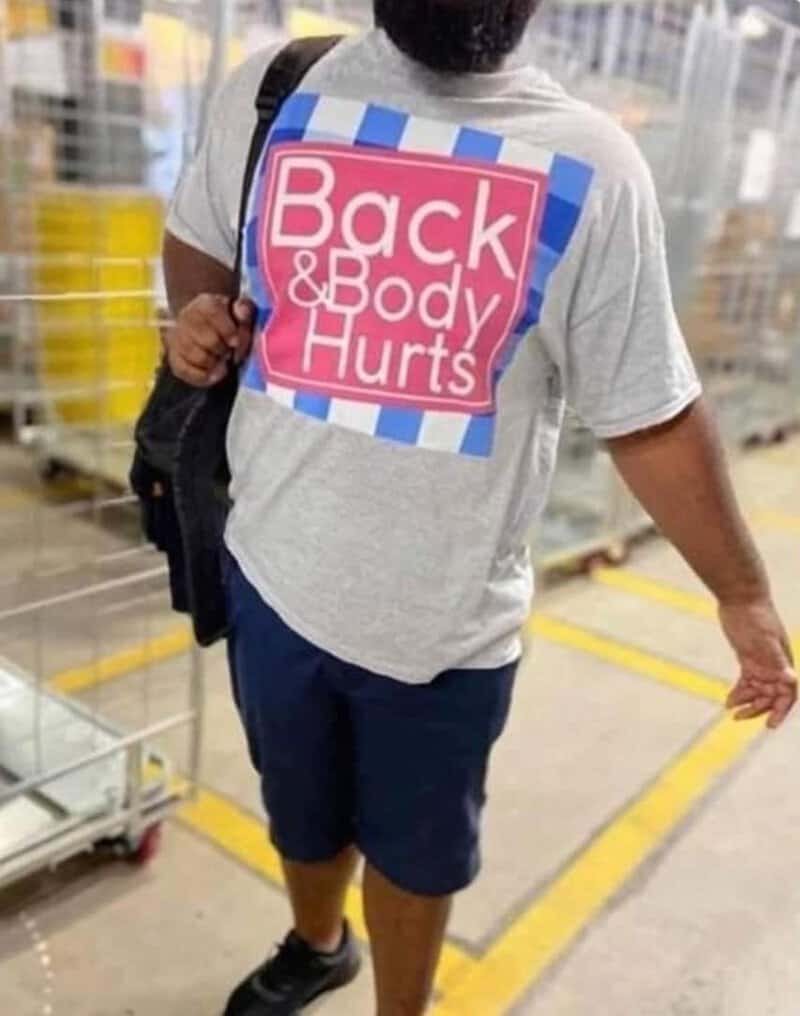 Person in a store wearing a T-shirt with 'Back & Body Hurts' printed on it.