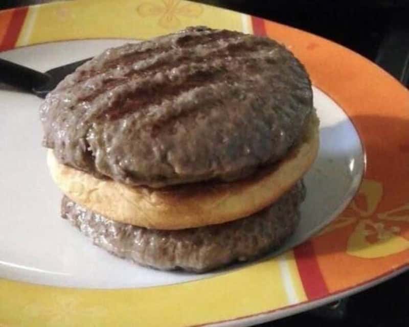 Unusual burger with two beef patties and a biscuit in the middle.