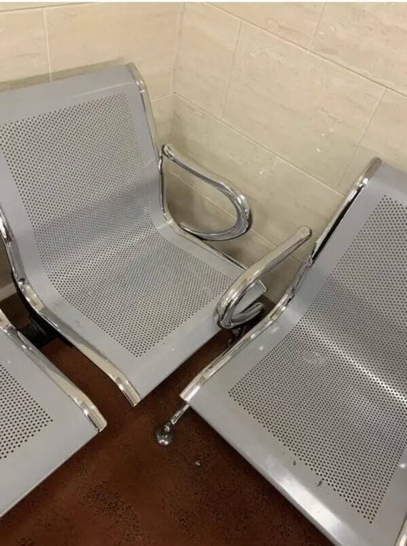Two metal chairs with armrests are broken and fallen on the floor.