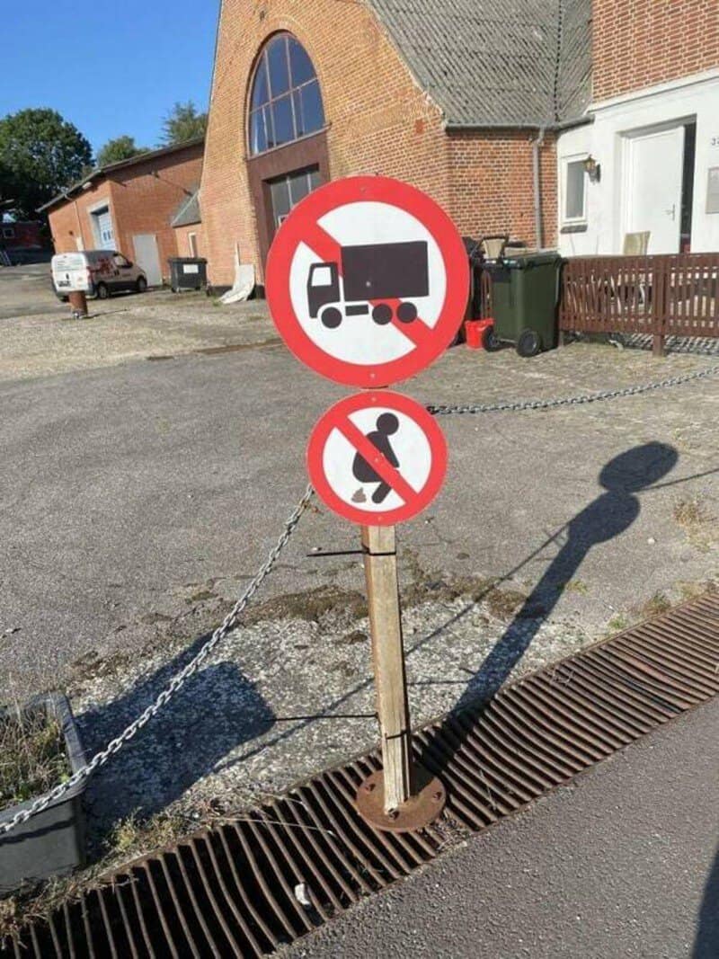 No trucks or dogs allowed sign on a pole outside a building.