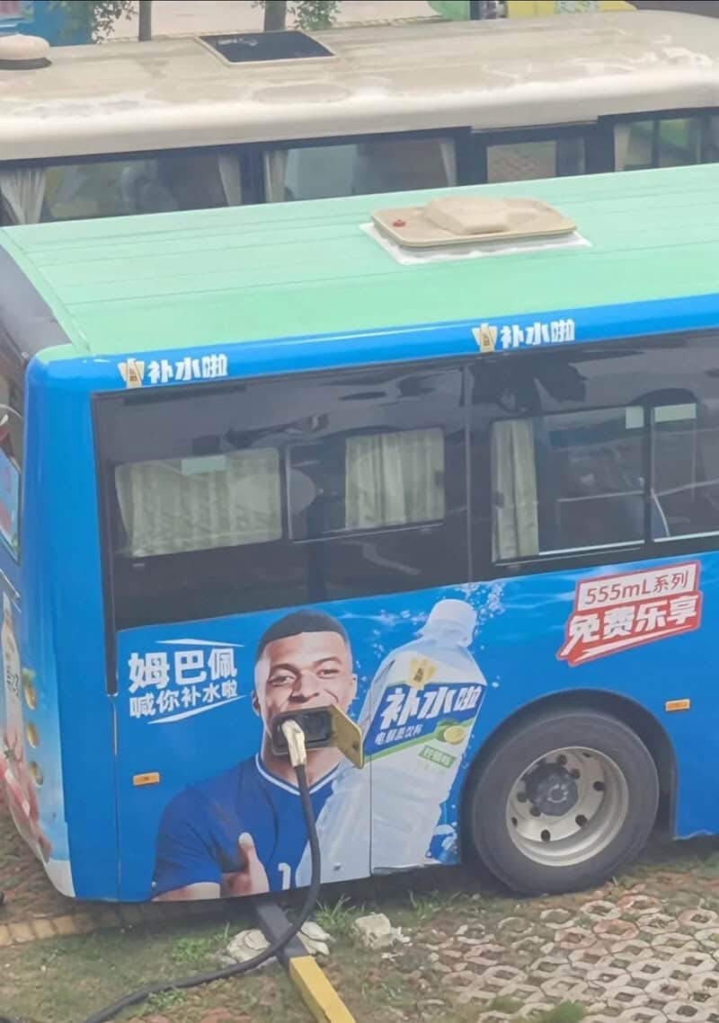 Miniature bus with a man holding a water bottle, advertising bottled water.