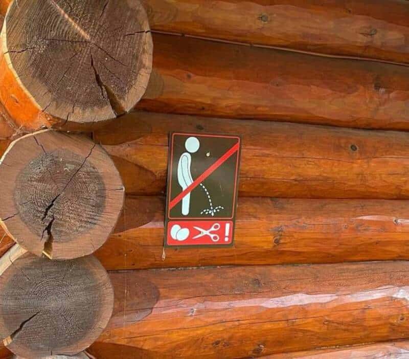 Sign showing not to urinate on the logs with a crossed-out figure urinating.