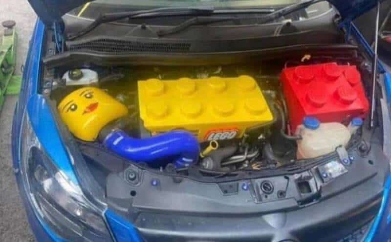 Car engine with LEGO-themed decorations, including a smiley face and LEGO bricks.