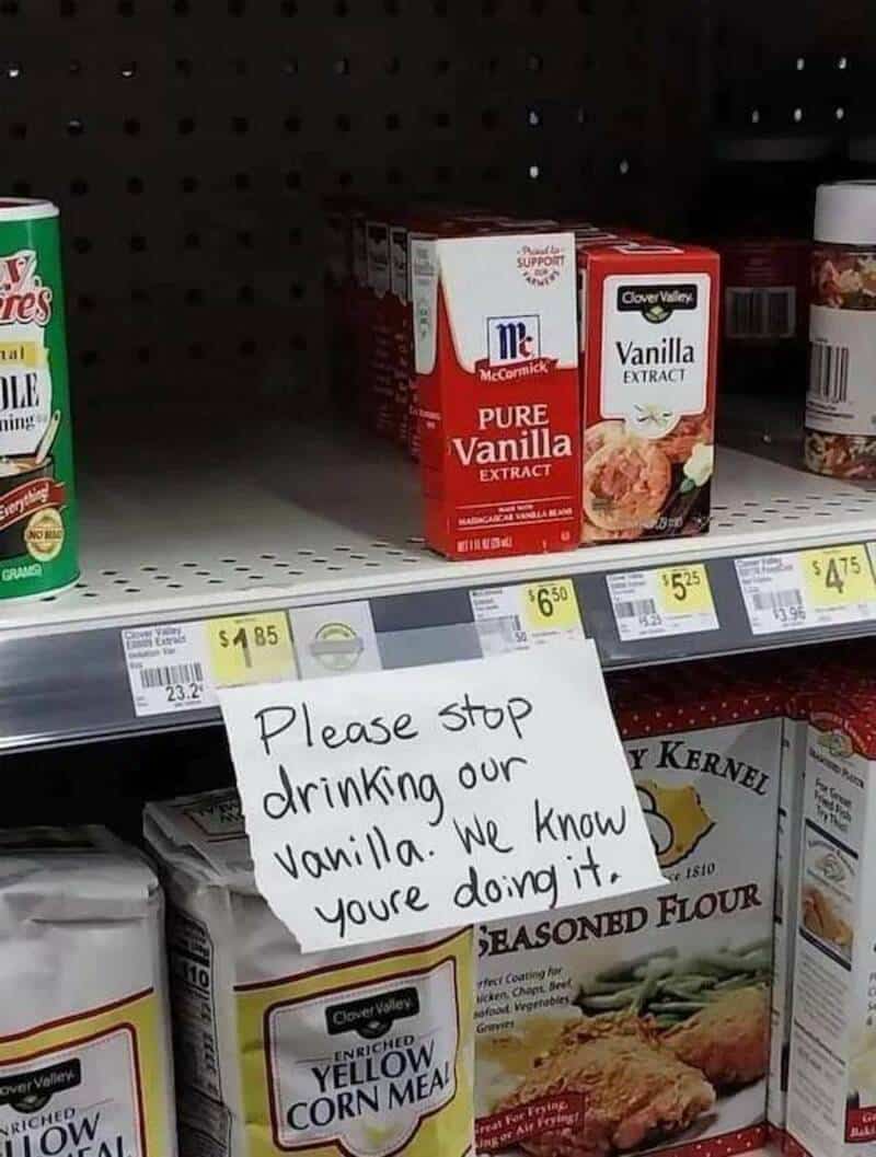 Sign on grocery shelf says 'Please stop drinking our vanilla. We know you're doing it.'.