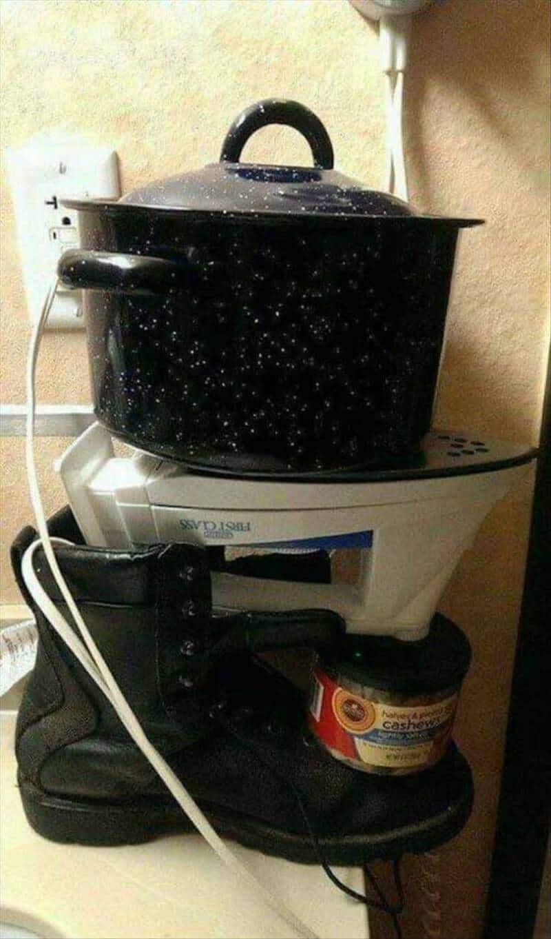 A black pot with a starry pattern on a white rice cooker, on a kitchen counter.