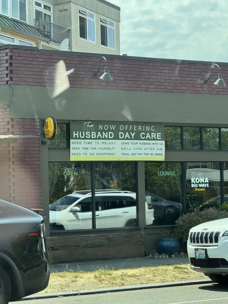 Sign advertising husband and wife day care with humorous message.