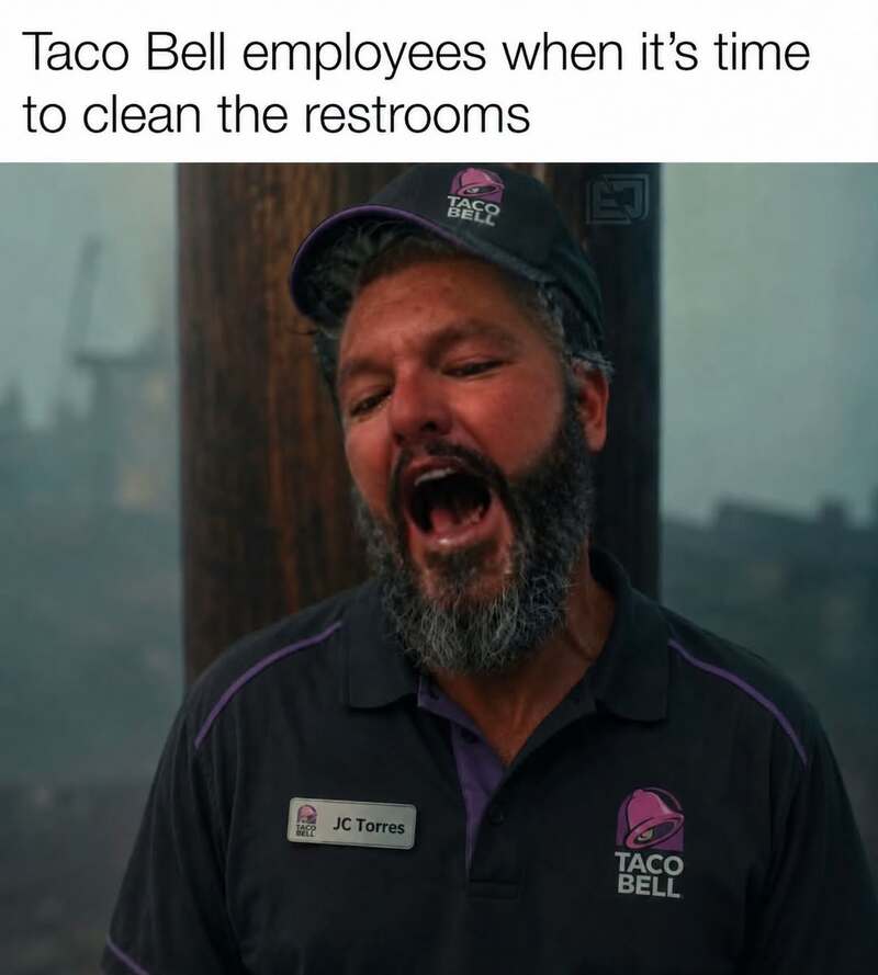 Taco Bell employee with mouth open, wearing uniform and cap, during restroom cleaning.
