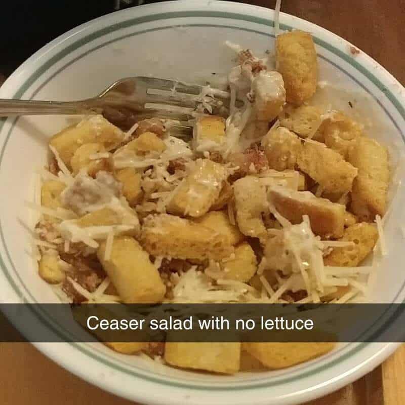 Caesar salad with croutons, cheese, and dressing in a bowl.