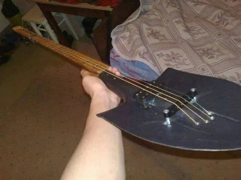 Person holding a guitar-shaped object that looks like a weapon.