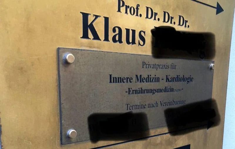 Sign for Prof. Dr. Klaus with blacked-out text and a metal plaque.