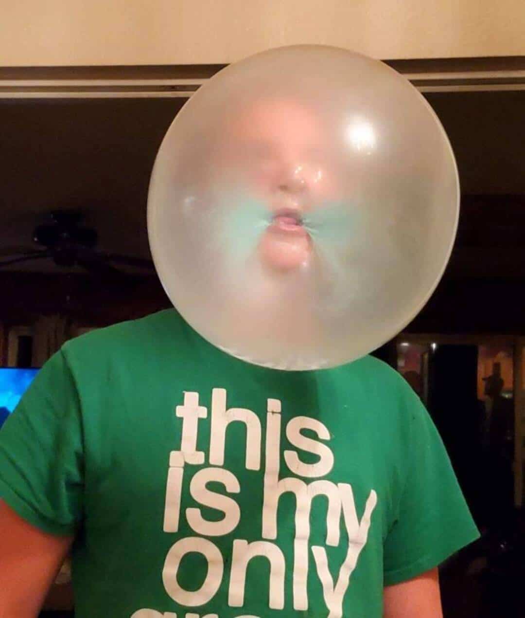 Person with a large transparent balloon over their face, making their lips look funny.