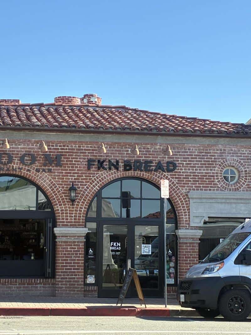 FKN BREAD storefront with brick facade and large arched windows.