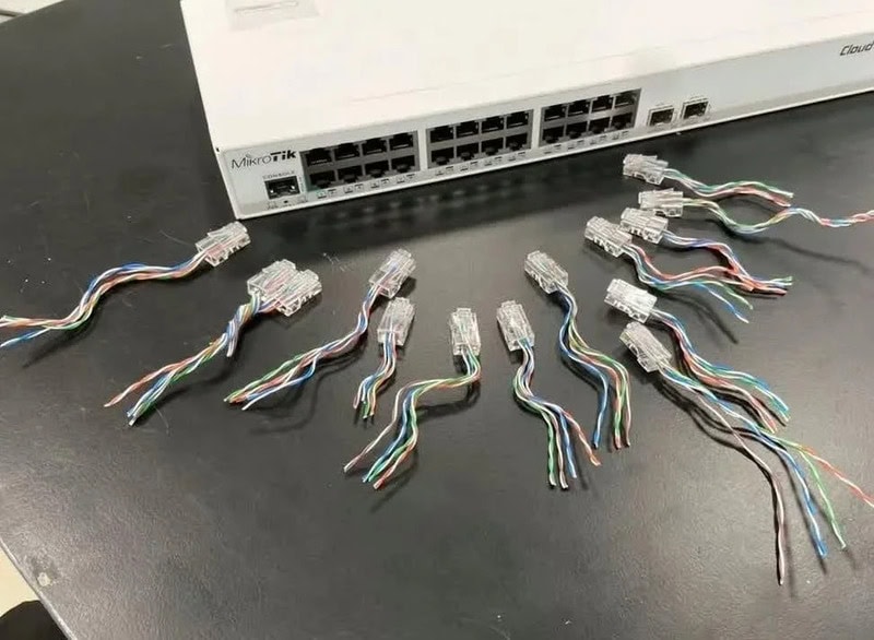 Multiple broken Ethernet cables with frayed wires on a black surface.