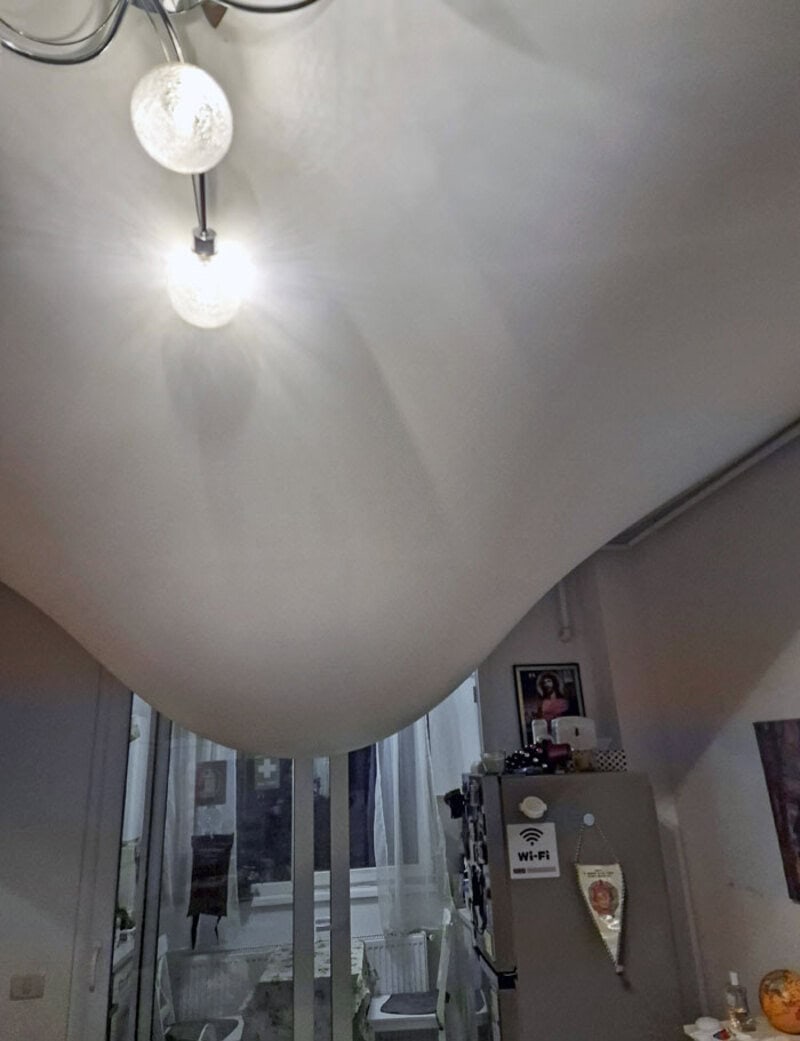 Ceiling with a curved design and hanging light fixtures in a room.