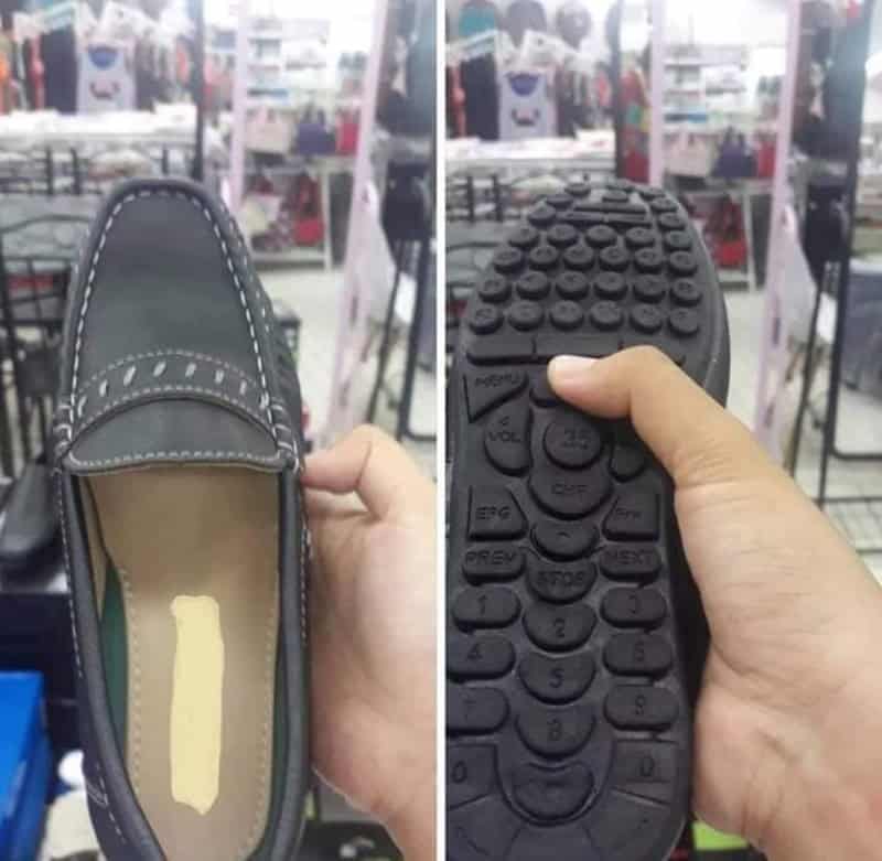 Hand holding a shoe and a shoe sole with buttons in a store.