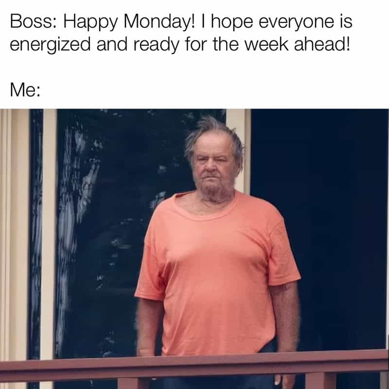 Man with tired expression in a pink T-shirt standing outside.