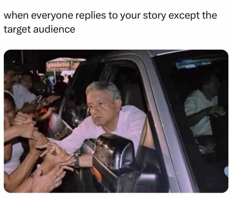 A man in a white shirt is surrounded by people reaching out to him.
